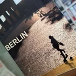 Frau, die in Berlin beim Shopping am Brandenburger Tor vorbei flaniert.