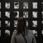 Frau steht vor Fotografien in einer Berliner Kunst-Galerie mit Schwarz-Weiß-Aufnahmen.