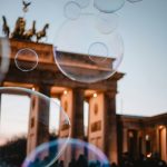 Brandenburger Tor in Berlin in der Abenddämmerung mit Seifenblasen eines Events im Fokus.