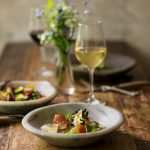 Wine and Dine in Berlin mit erlesenen Weinen und hervorragenden Gerichten serviert auf einem Holztisch mit rustikaler Dekoration.