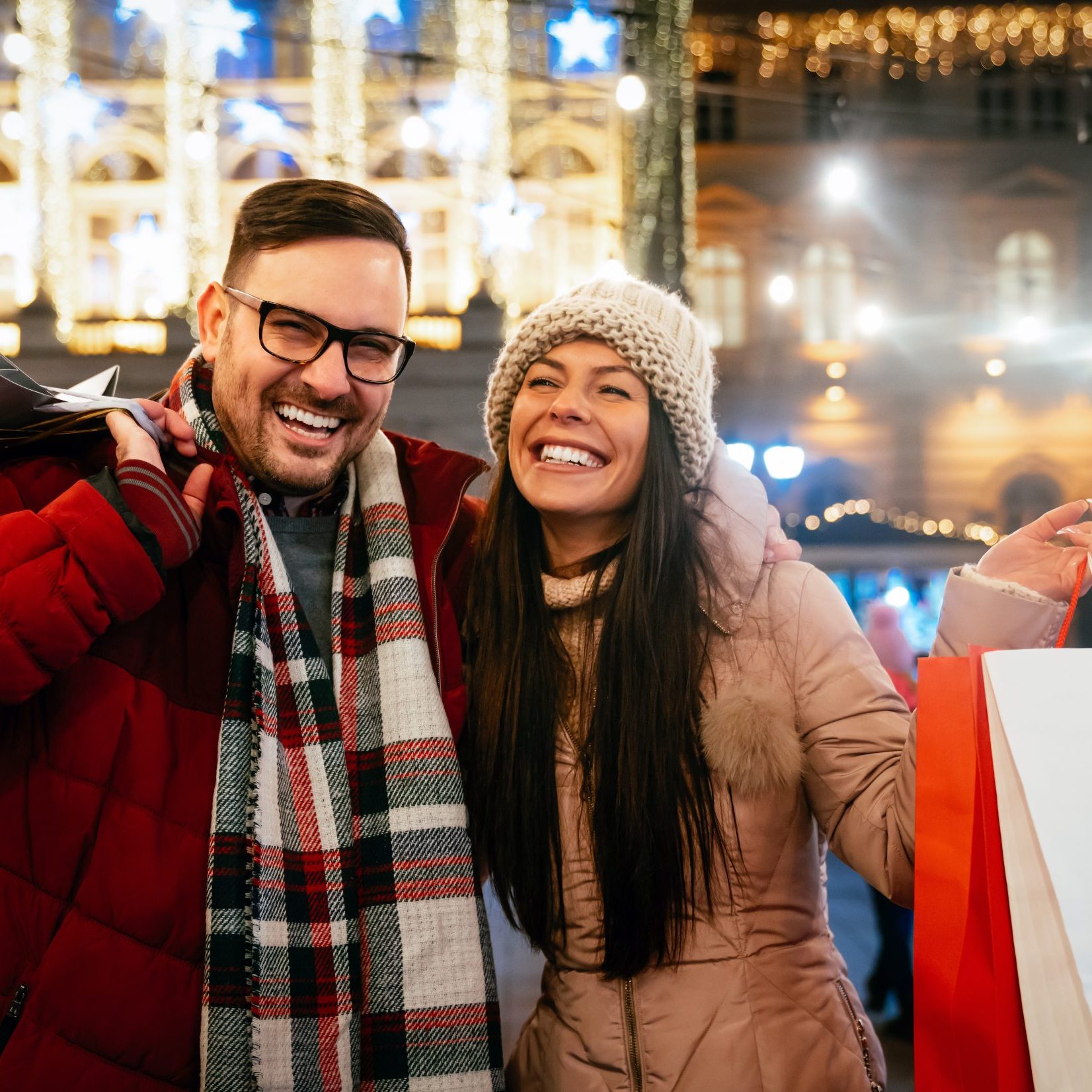 Portrait of happy smiling couple shopping for Christmas in the city. People holiday happiness sale concept