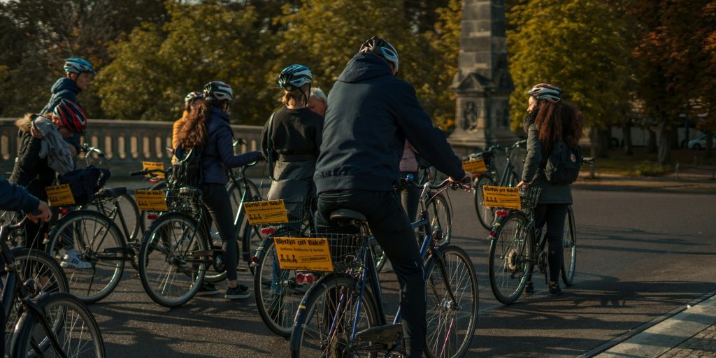 Menschen auf dem Rad mit Helm bei einer geführten Radtour durch Berlin in einer Gruppe für Berlin Besucher.